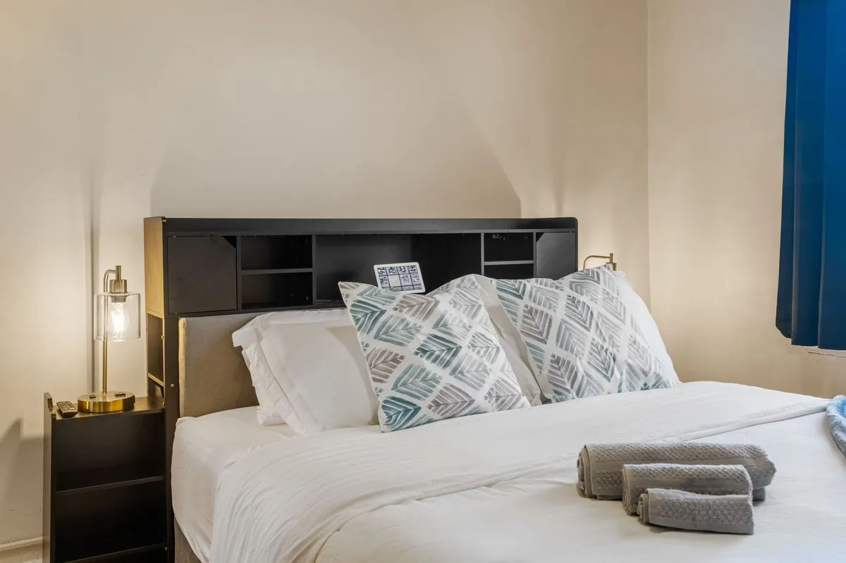 Queen bed with storage headboard, reading lamps, and smart display